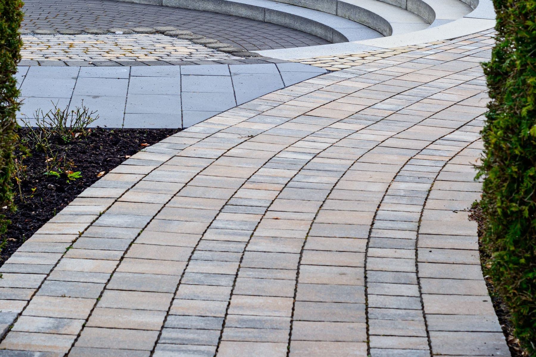 Curved paver walkway leading to a sunken seating area